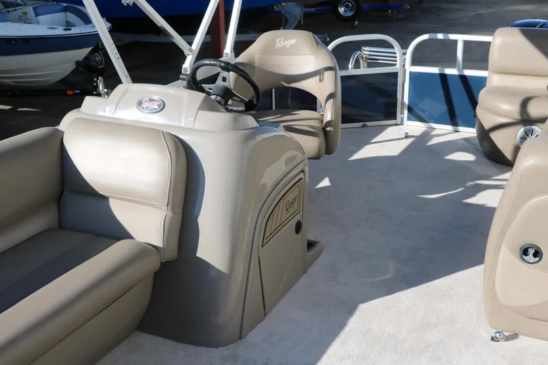 Slide: The Image of 2021 Ranger RP200C pontoon boat interior with beige seating and steering console. - 23