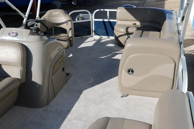 Slide: The Image of Interior of a 2021 Ranger RP200C pontoon boat with beige seating and steering console. - 24