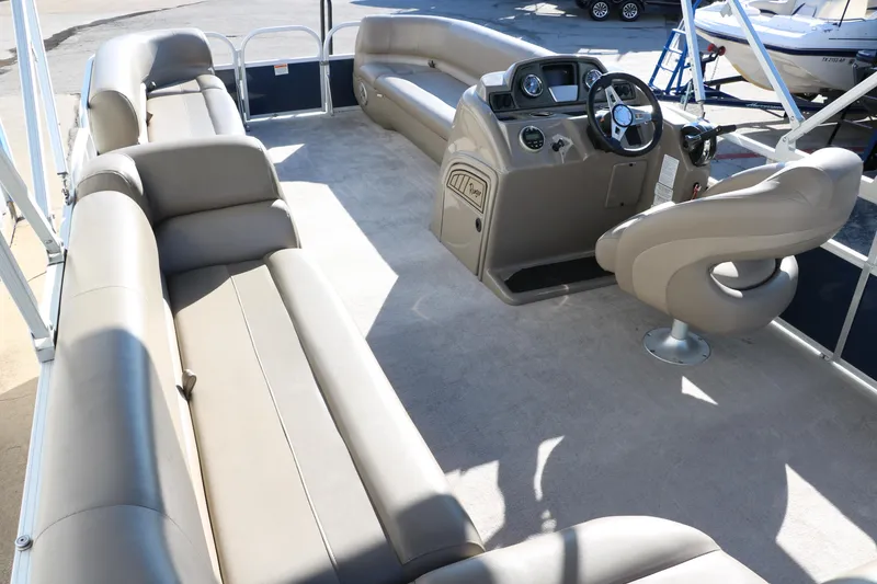 Slide: The Image of 2021 Ranger RP200C pontoon boat interior with beige seating and helm. - 25