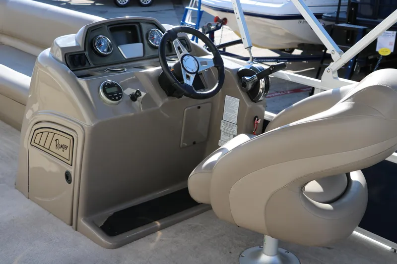 Slide: The Image of 2021 Ranger RP200C boat console with steering wheel and beige captain's chair. - 28