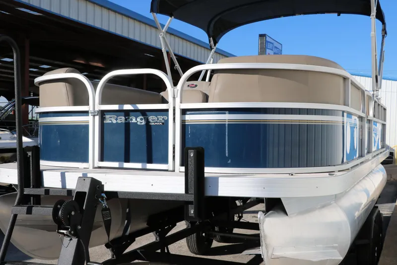 Slide: The Image of 2021 Ranger RP200C pontoon boat with blue and white exterior on a trailer. - 9