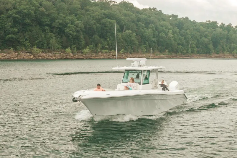 Slide: The Image of 2023 HCB 39 Speciale boat cruising on a lake with lush green forest in the background. - 16