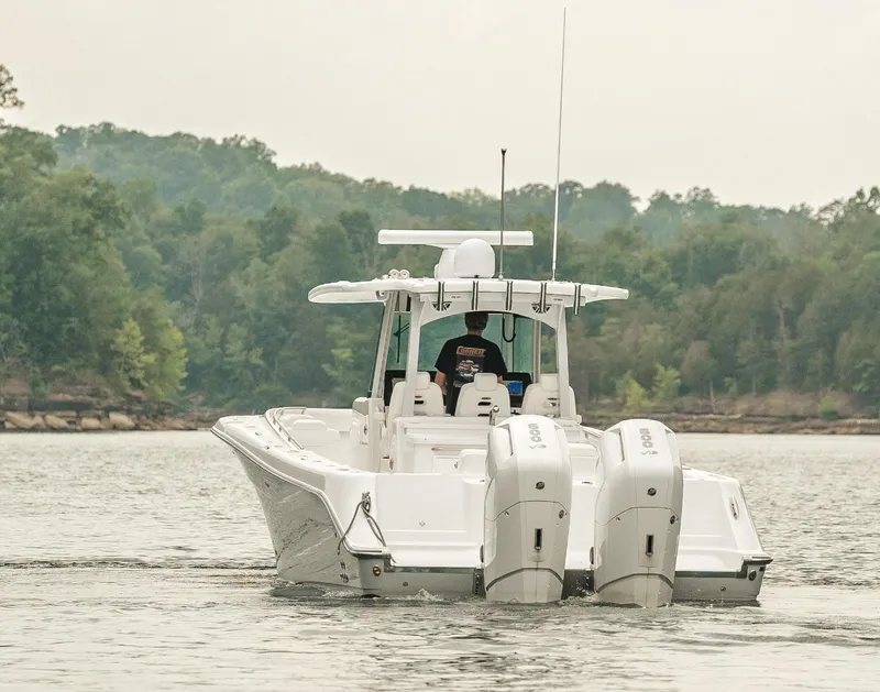 Slide: The Image of 2023 HCB 39 Speciale boat cruising on a lake with twin outboard engines. - 4