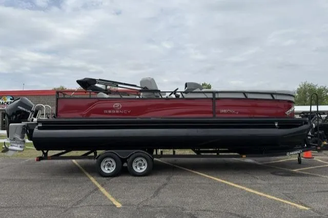 The Image of 2023 Regency 250 DL3 pontoon boat on trailer in parking lot. - 0
