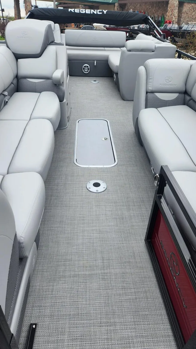 Slide: The Image of 2023 Regency 250 DL3 pontoon boat with spacious seating and modern interior design. - 2
