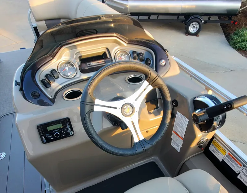 Slide: The Image of 2023 Sun Tracker SportFish 22 XP3 boat dashboard with steering wheel and control panel. - 2
