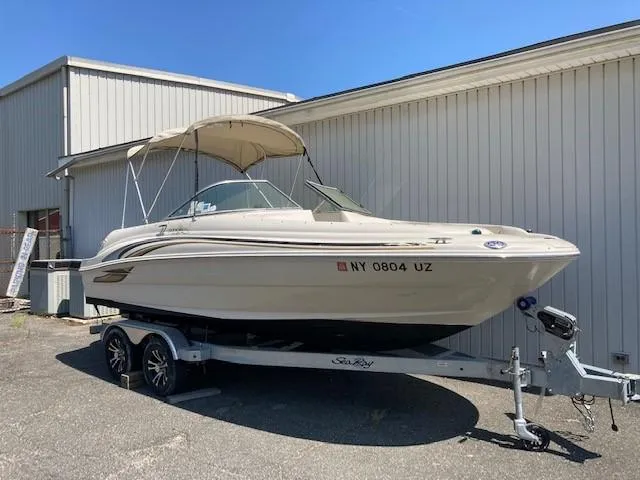 The Image of 2001 Sea Ray 190 Sundeck boat on trailer, parked outside a building. - 0