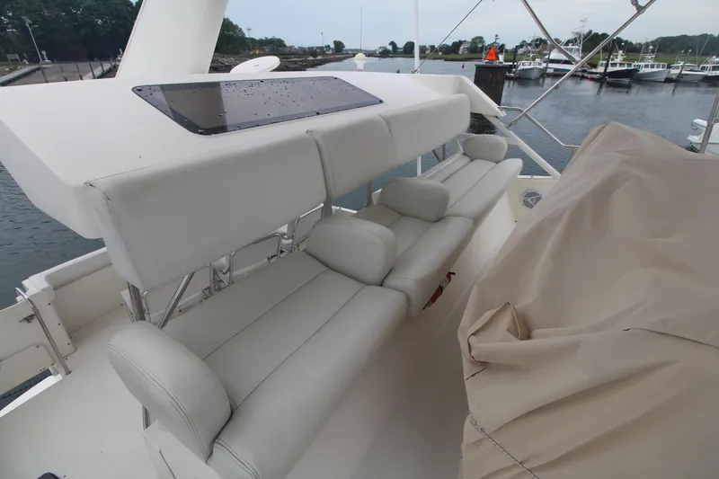 Slide: The Image of 2000 Silverton 392 Motor Yacht with white seating and covered controls, docked at a marina. - 18