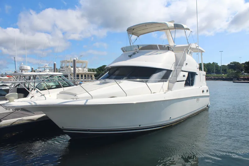 Slide: The Image of 2000 Silverton 392 Motor Yacht docked in a marina under a blue sky. - 2