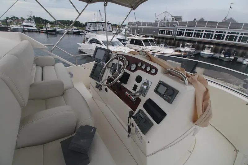 Slide: The Image of 2000 Silverton 392 Motor Yacht helm with controls, docked at marina. - 26