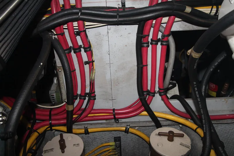 Slide: The Image of Engine room wiring of a 2000 Silverton 392 Motor Yacht, featuring red and yellow cables. - 34