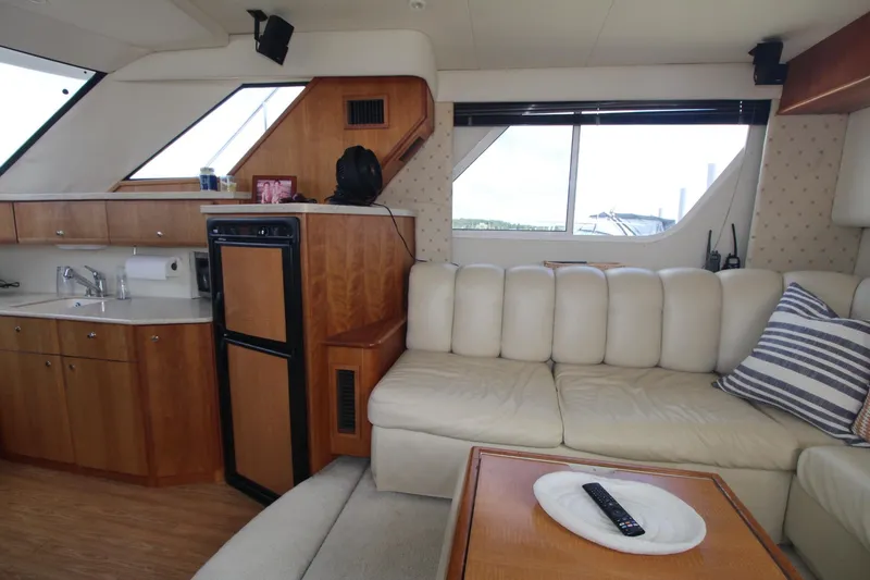 Slide: The Image of Interior of 2000 Silverton 392 Motor Yacht with sofa, kitchenette, and window view. - 39