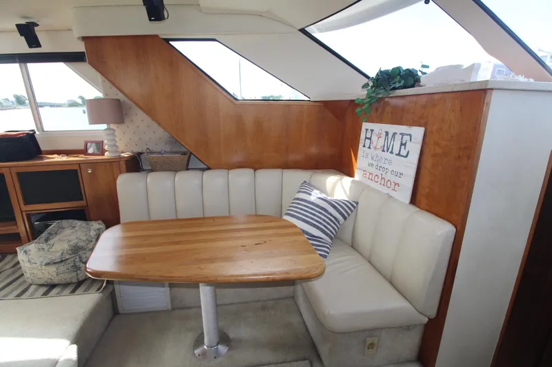 Slide: The Image of 2000 Silverton 392 Motor Yacht interior with cozy dining area and wooden accents. - 41