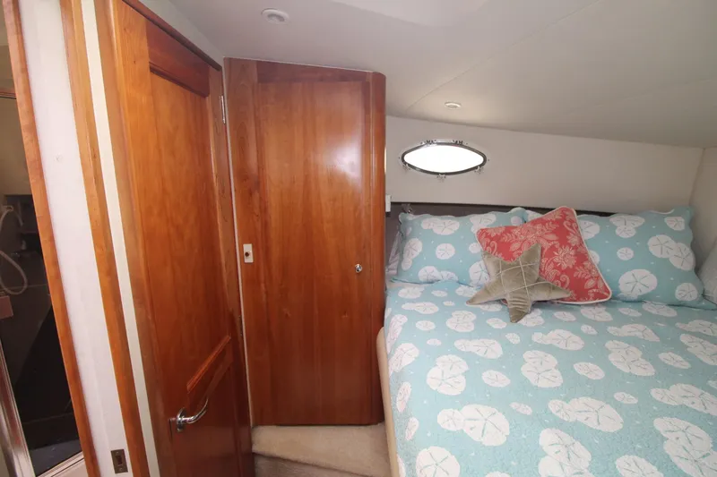 Slide: The Image of Cozy bedroom in 2000 Silverton 392 Motor Yacht with patterned bedding and wooden cabinetry. - 46