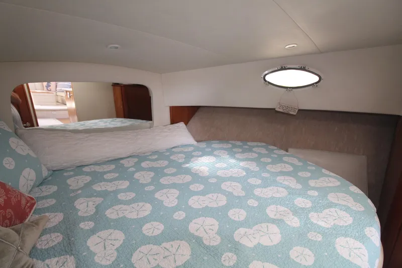 Slide: The Image of Cozy bedroom in 2000 Silverton 392 Motor Yacht with patterned bedding and porthole window. - 48