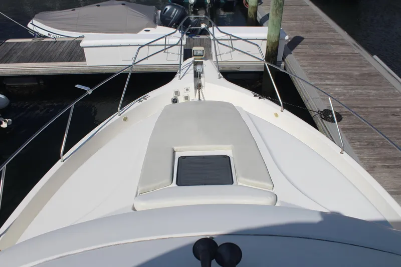 Slide: The Image of 2000 Silverton 392 Motor Yacht bow view at dock, featuring sleek design and spacious deck. - 7