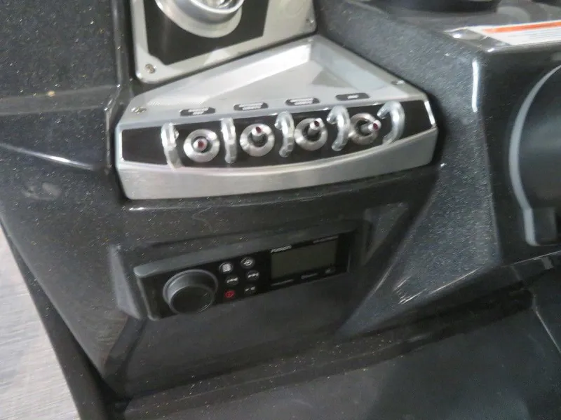 Slide: The Image of Control panel of 2023 Crest Caribbean RS 250 SLS CP3 boat with switches and radio. - 21