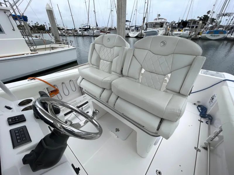 Slide: The Image of 2021 Edgewater 262CC boat interior, white seating and storage compartments. - 12