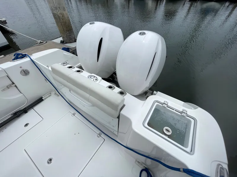 Slide: The Image of 2021 Edgewater 262CC boat interior, featuring a clean, white cabin with storage compartments. - 13