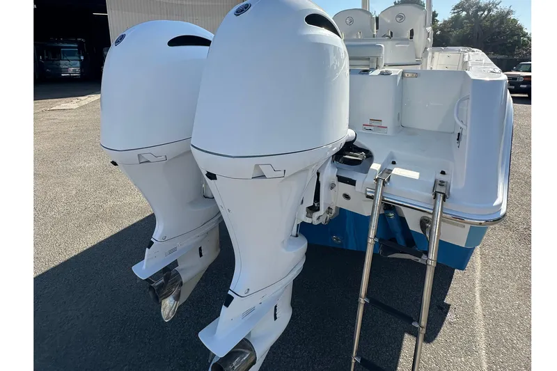 Slide: The Image of 2021 Edgewater 262CC boat with dual outboard engines and a boarding ladder. - 22