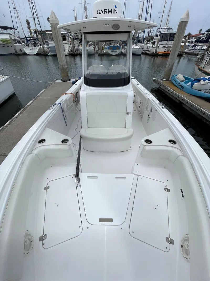 Slide: The Image of 2021 Edgewater 262CC boat docked at a marina with other boats. - 5