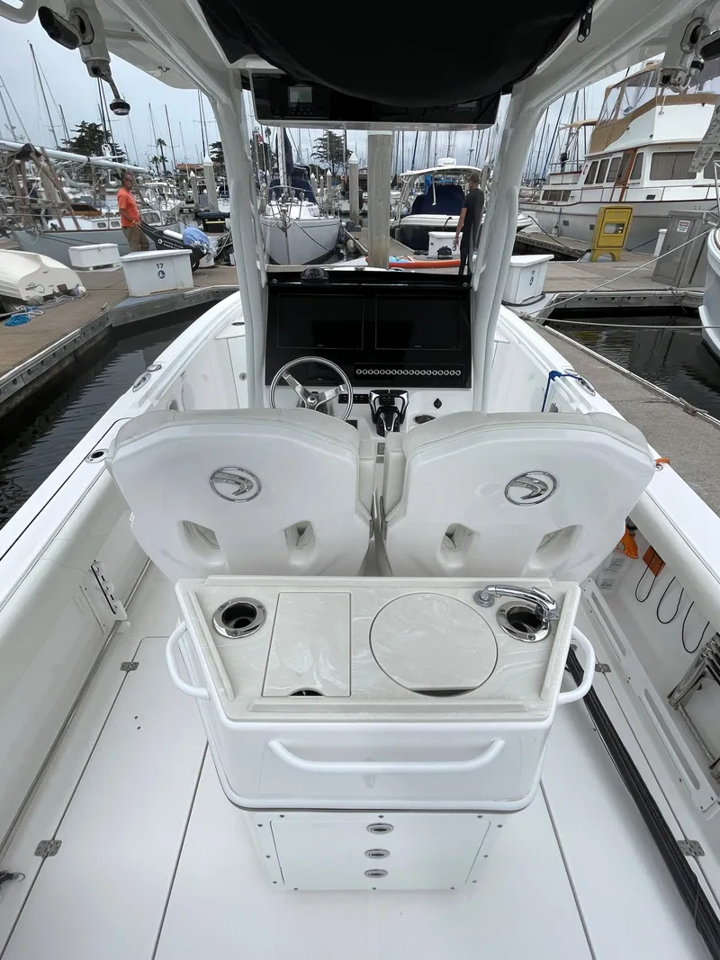 Slide: The Image of 2021 Edgewater 262CC boat with twin outboard engines docked at a marina. - 7