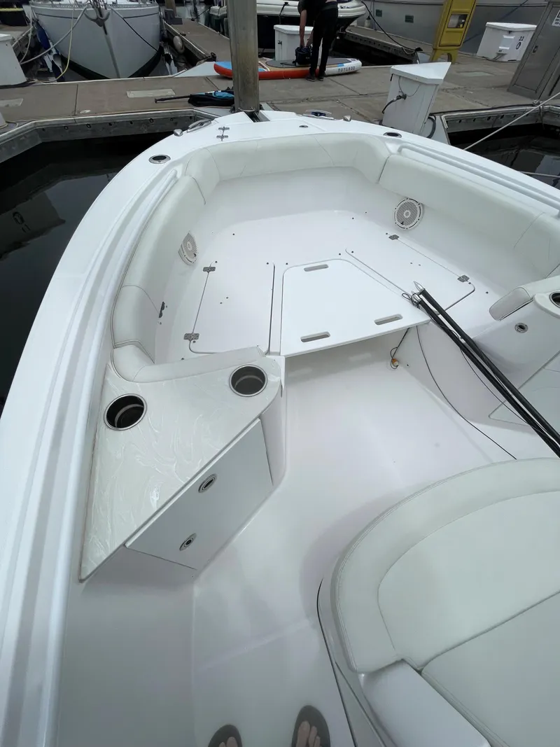 Slide: The Image of 2021 Edgewater 262CC boat docked, featuring dual outboard engines and spacious deck. - 9