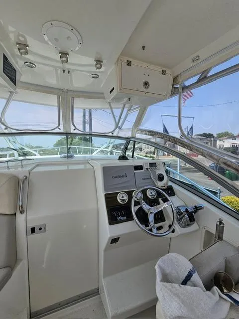Slide: The Image of 2009 Mako 284 Express boat cockpit with steering wheel and navigation equipment. - 11
