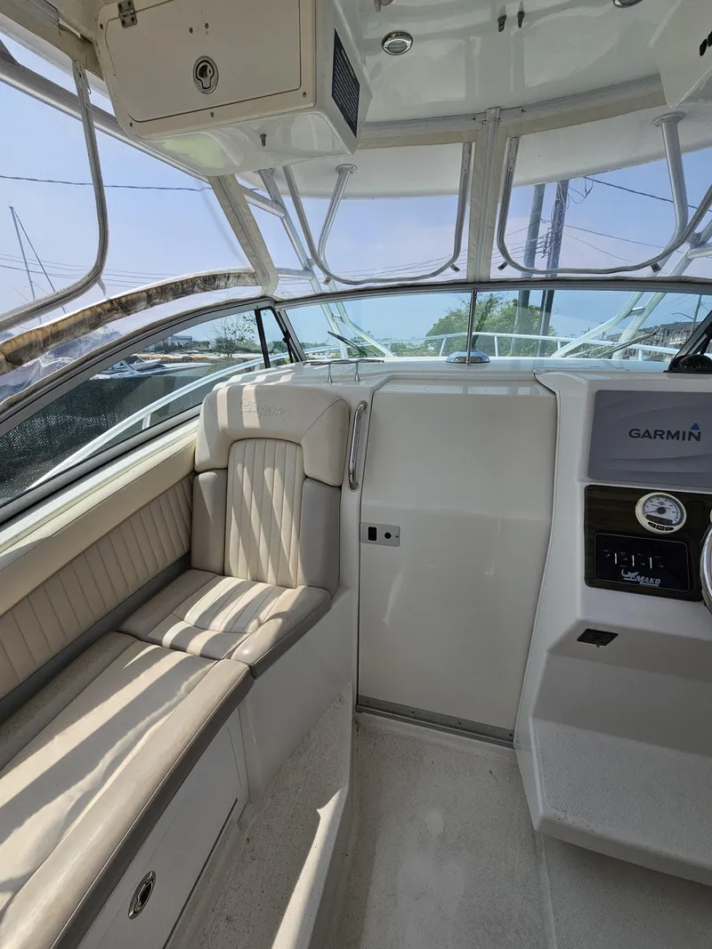 Slide: The Image of Interior of a 2009 Mako 284 Express boat with seating and Garmin equipment. - 15