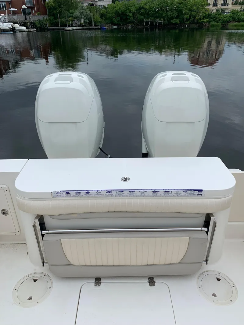 Slide: The Image of 2009 Mako 284 Express boat with twin outboard engines on a calm lake. - 21