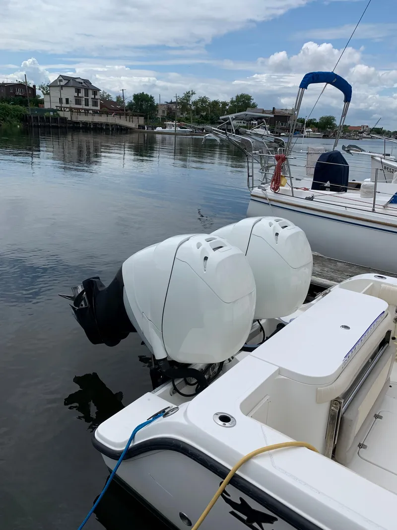 Slide: The Image of 2009 Mako 284 Express boat with twin outboard engines docked by the water. - 22