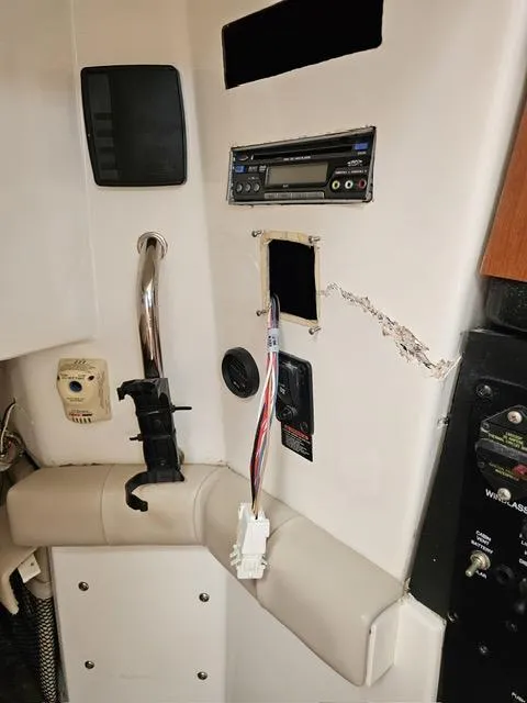 Slide: The Image of 2009 Mako 284 Express boat interior with exposed wiring and control panel. - 28