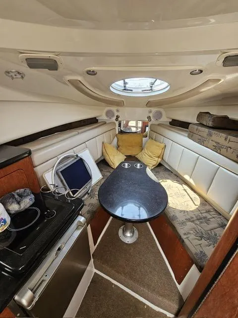 Slide: The Image of 2009 Mako 284 Express cabin interior with seating, table, and kitchenette. - 33