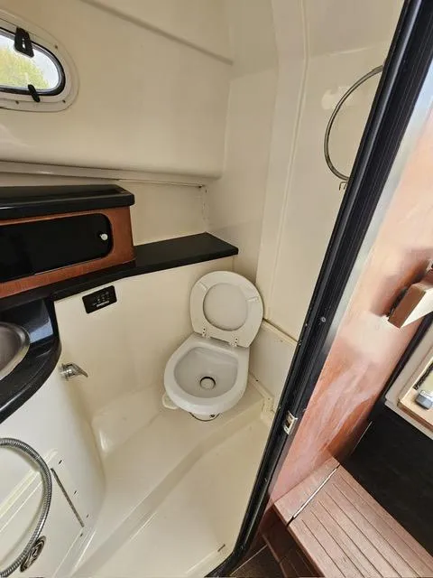 Slide: The Image of 2009 Mako 284 Express boat bathroom interior with toilet and sink. - 38