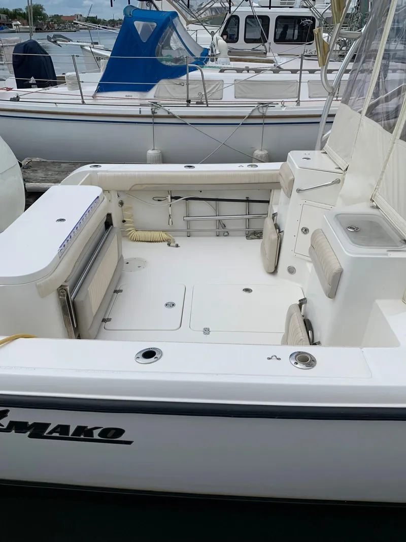 Slide: The Image of 2009 Mako 284 Express boat docked, featuring spacious deck and seating. - 6