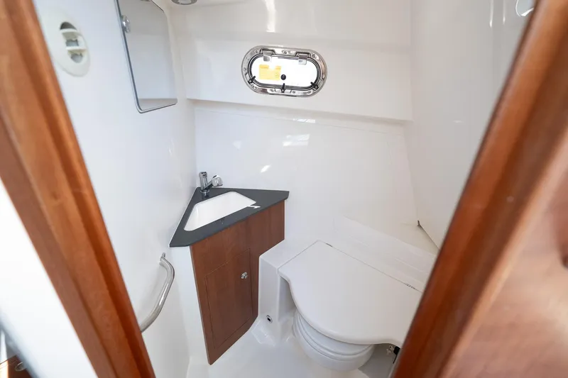 Slide: The Image of 2024 Pursuit OS 325 Offshore boat bathroom with sink and toilet. - 11