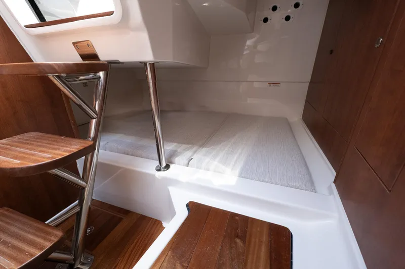 Slide: The Image of 2024 Pursuit OS 325 Offshore cabin interior with wooden steps and sleek design. - 12