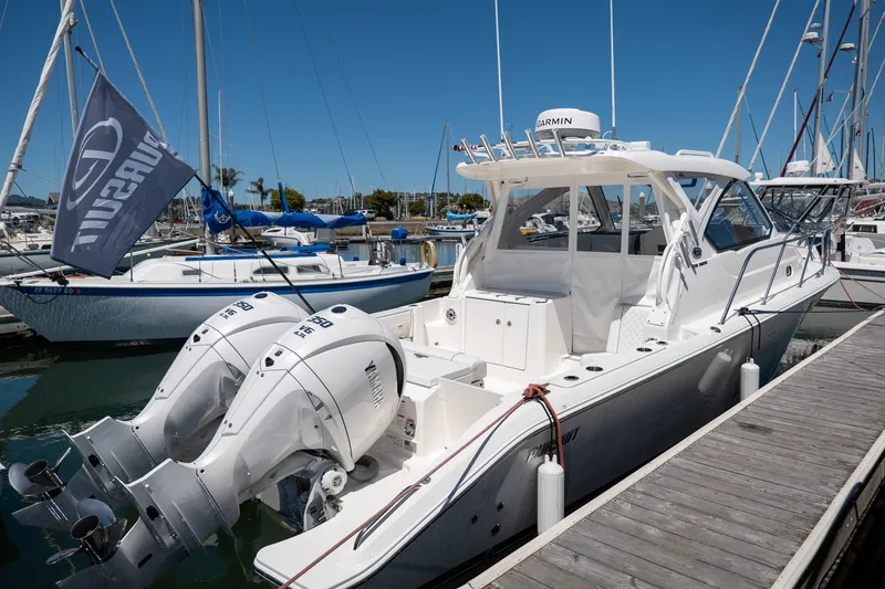 Slide: The Image of 2024 Pursuit OS 325 Offshore boat docked at marina with twin engines. - 16
