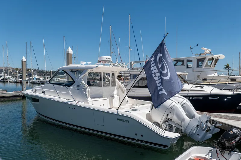 Slide: The Image of 2024 Pursuit OS 325 Offshore boat docked in marina under clear blue sky. - 3