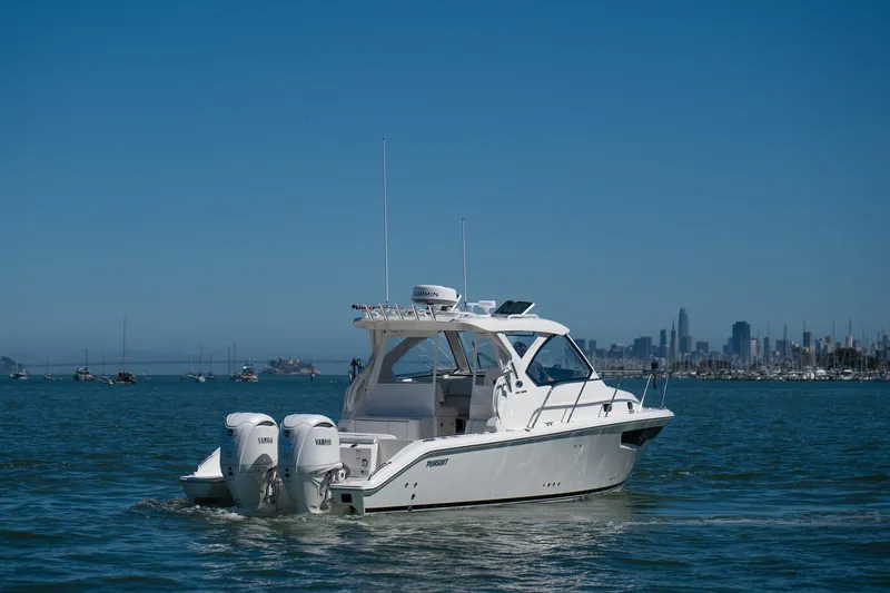Slide: The Image of 2024 Pursuit OS 325 Offshore boat on water with city skyline background. - 7