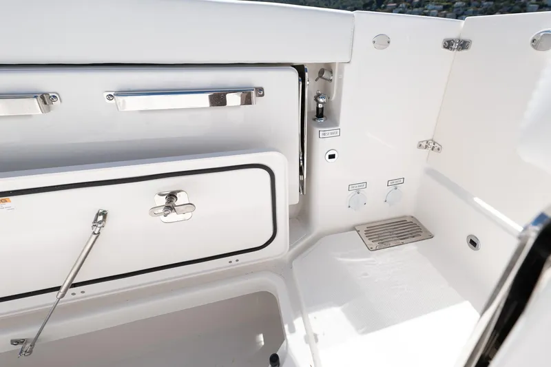 Slide: The Image of 2024 Pursuit OS 325 Offshore boat interior with storage compartments and sleek design. - 8