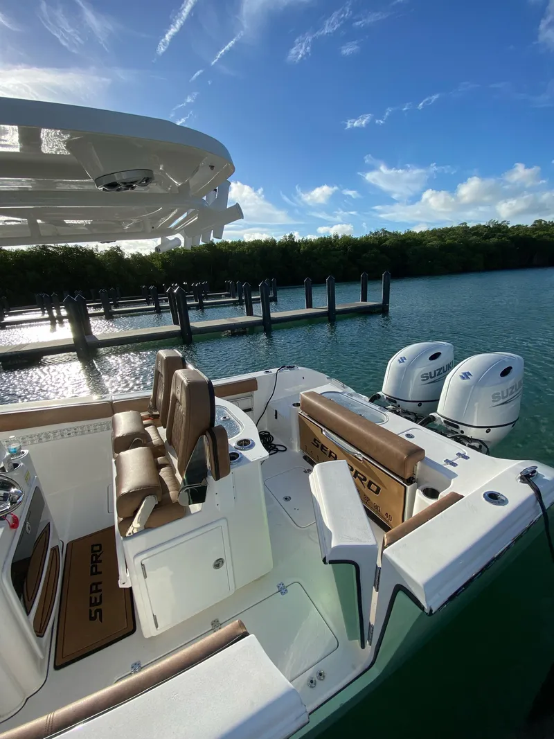Slide: The Image of 2021 Sea Pro 259 DLX boat docked with dual Suzuki outboard engines. - 4
