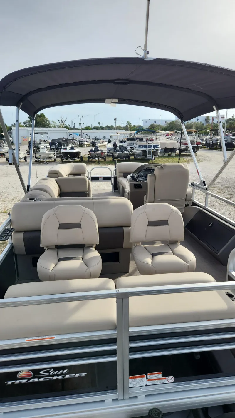Slide: The Image of 2023 Sun Tracker SportFish 22 XP3 pontoon boat with beige seating and canopy. - 3