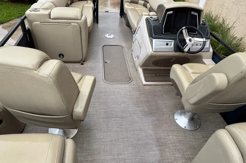 Slide: The Image of 2023 Regency 230 LE3 boat interior with beige seating and modern steering console. - 5