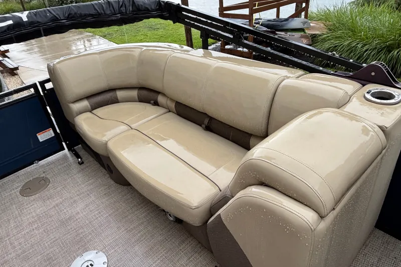 Slide: The Image of Luxurious beige seating on 2023 Regency 230 LE3 pontoon boat, wet from rain. - 4