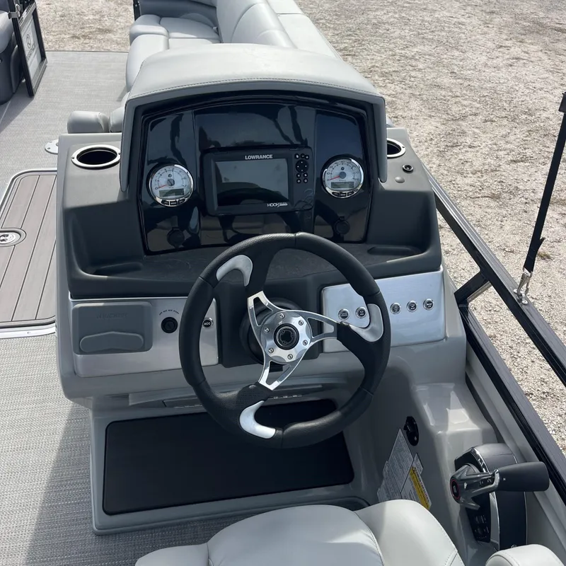 Slide: The Image of 2023 Regency 250 DL3 boat dashboard with steering wheel and control panel. - 2