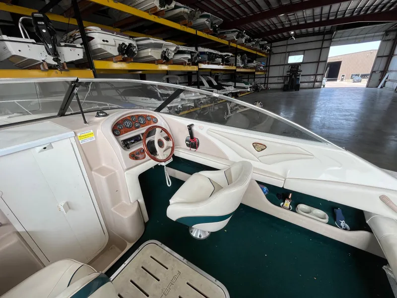 Slide: The Image of 1997 Monterey 236 Montura boat interior with steering wheel and seating in storage facility. - 11
