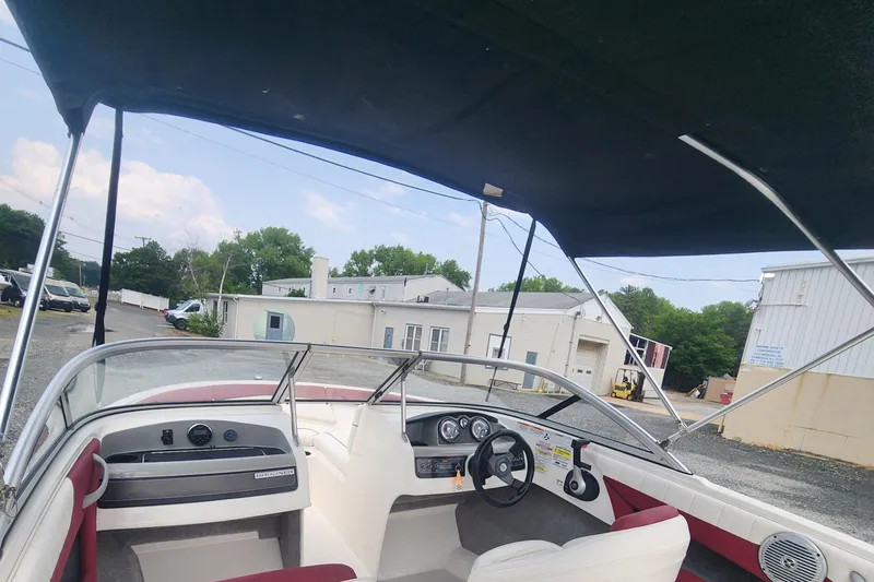 Slide: The Image of 2018 Bayliner 185 Bowrider boat interior with canopy, dashboard, and steering wheel. - 14