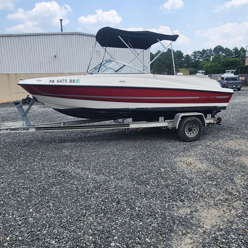 Slide: The Image of 2018 Bayliner 185 Bowrider boat on a trailer with a black canopy. - 18