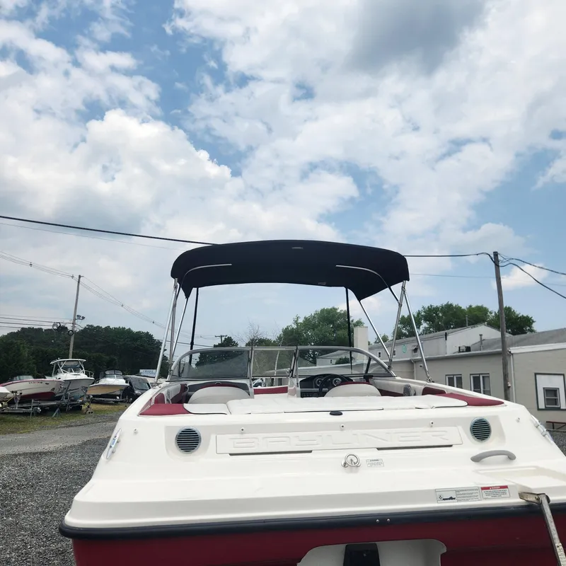 Slide: The Image of 2018 Bayliner 185 Bowrider boat with canopy in outdoor storage area. - 24